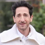 Adrien Brody posing confidently at a film premiere, showcasing his signature style and charisma as highlighted in the article introduction.