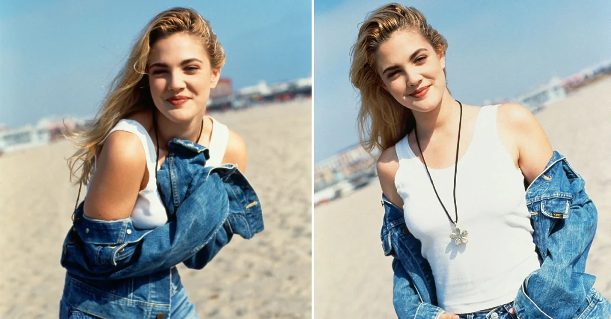 Drew Barrymore smiling with wavy light brown hair and casual clothes against a plain background.