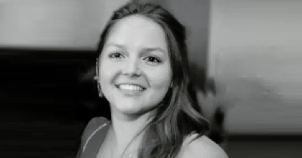 Lucy Bolam smiling with long brown hair, wearing a black top in a close-up photo.