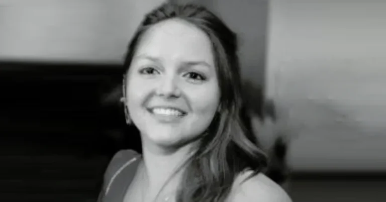 Lucy Bolam smiling with long brown hair, wearing a black top in a close-up photo.