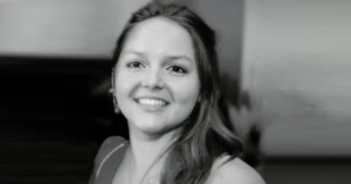 Lucy Bolam smiling with long brown hair, wearing a black top in a close-up photo.