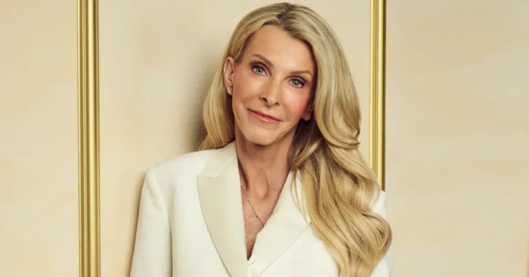 Joan Vassos, 61, Golden Bachelorette, wearing a black dress and holding a gold rose against a gold backdrop
