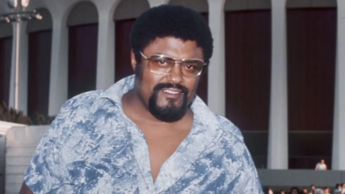 Rosey Grier posing with football memorabilia and awards — a visual snapshot representing Rosey Grier net worth and his multifaceted career earnings.