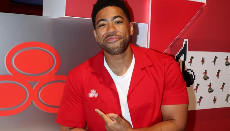 Kevin Miles Net Worth — Actor Kevin Miles, famously known as Jake from State Farm, posing confidently in a sleek suit, symbolizing his rising wealth and success.