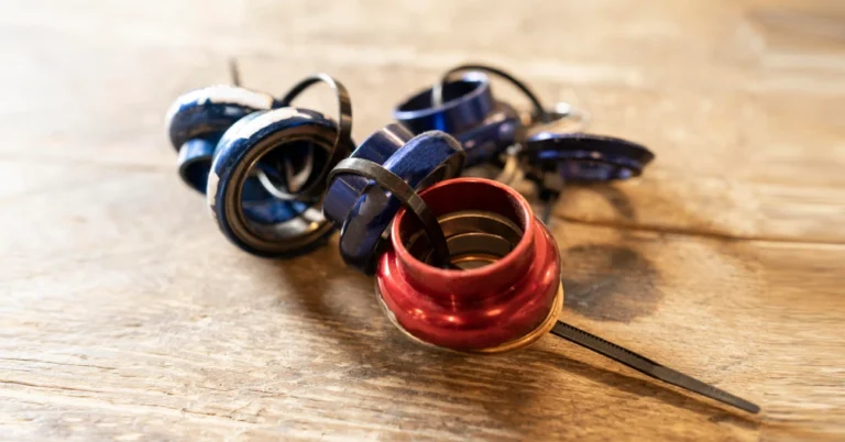 Thread repair kit for damaged bolts and nuts with helicoil inserts, taps, drill bits, and installation tools laid out on workbench
